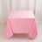 Pink tablecloth draped over a table against a neutral background.