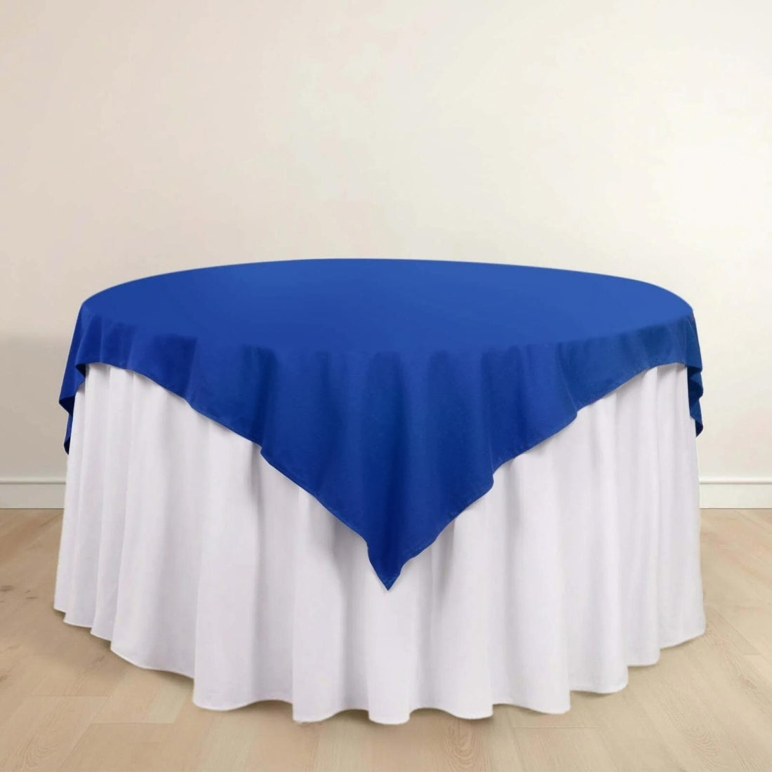Blue tablecloth on a round table with white skirt.