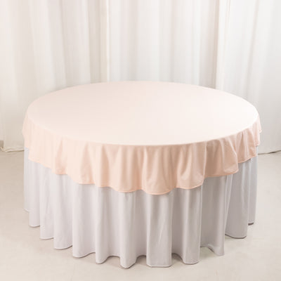 Round table with a soft pink tablecloth and white skirt