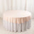 Round table covered with a soft pink tablecloth on a white table skirt