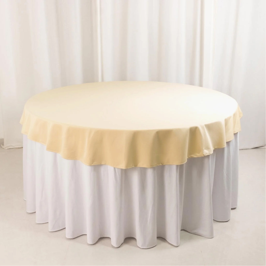 Round table with a yellow tablecloth and white skirt