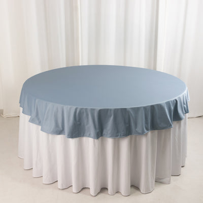 Round table with blue and white tablecloths, studio shot.
