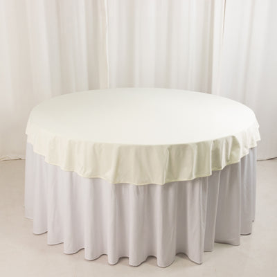 Round table with cream tablecloth and white skirt, studio isolation shot.
