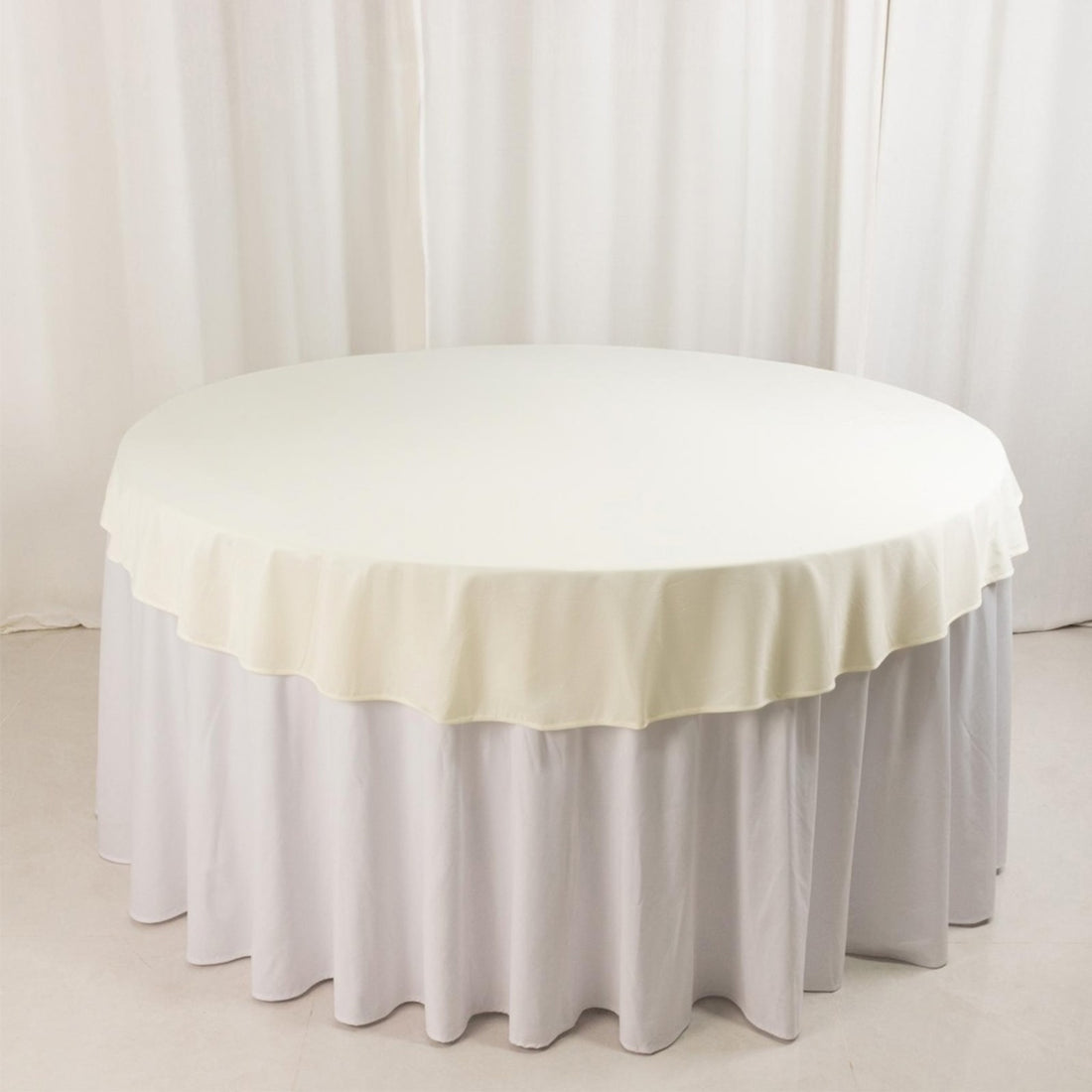 Round table with a cream tablecloth and white skirt