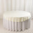 Round table with a cream tablecloth and white skirt