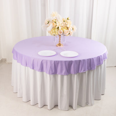Round table with lavender tablecloth and floral centerpiece arrangement.