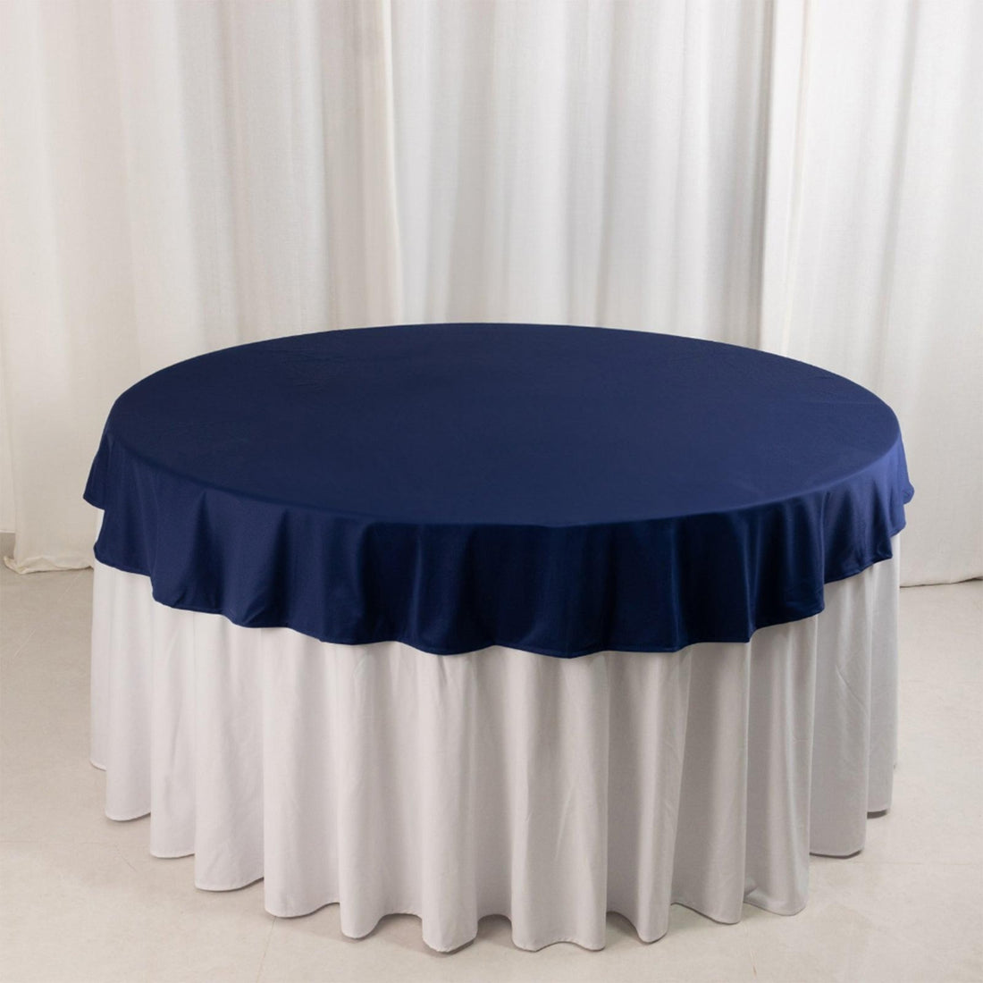 Navy blue tablecloth with white underskirt on round table