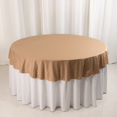Round table with a beige tablecloth draped elegantly over a white table.