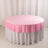 Round table with a pink tablecloth and white skirt.