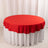 Red round tablecloth draped over a white table.