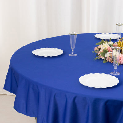 Round blue tablecloth with white plates and floral centerpiece.