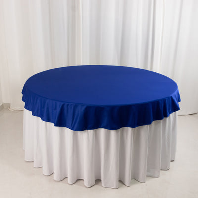 Blue round tablecloth draped over a white table.