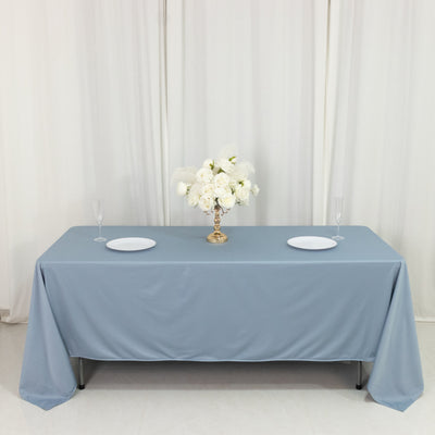 Elegant blue tablecloth with white plates and floral centerpiece
