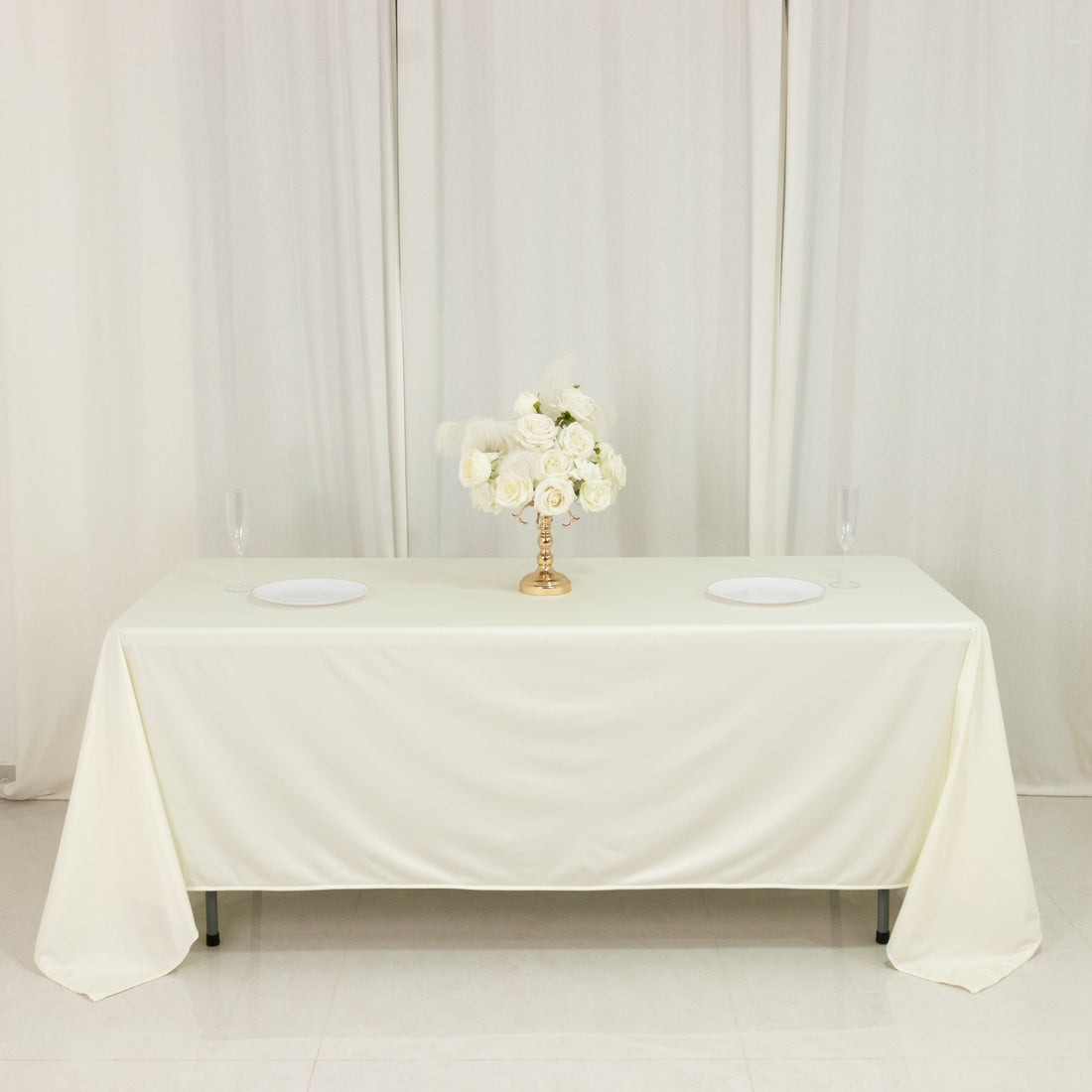 Elegant white table set for a formal event with floral centerpiece.