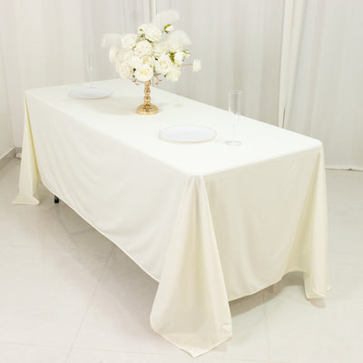 Elegant white table set with floral centerpiece and dinnerware.
