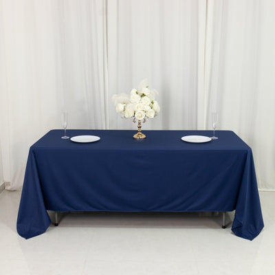 Navy tablecloth with white plates and floral centerpiece on a banquet table.