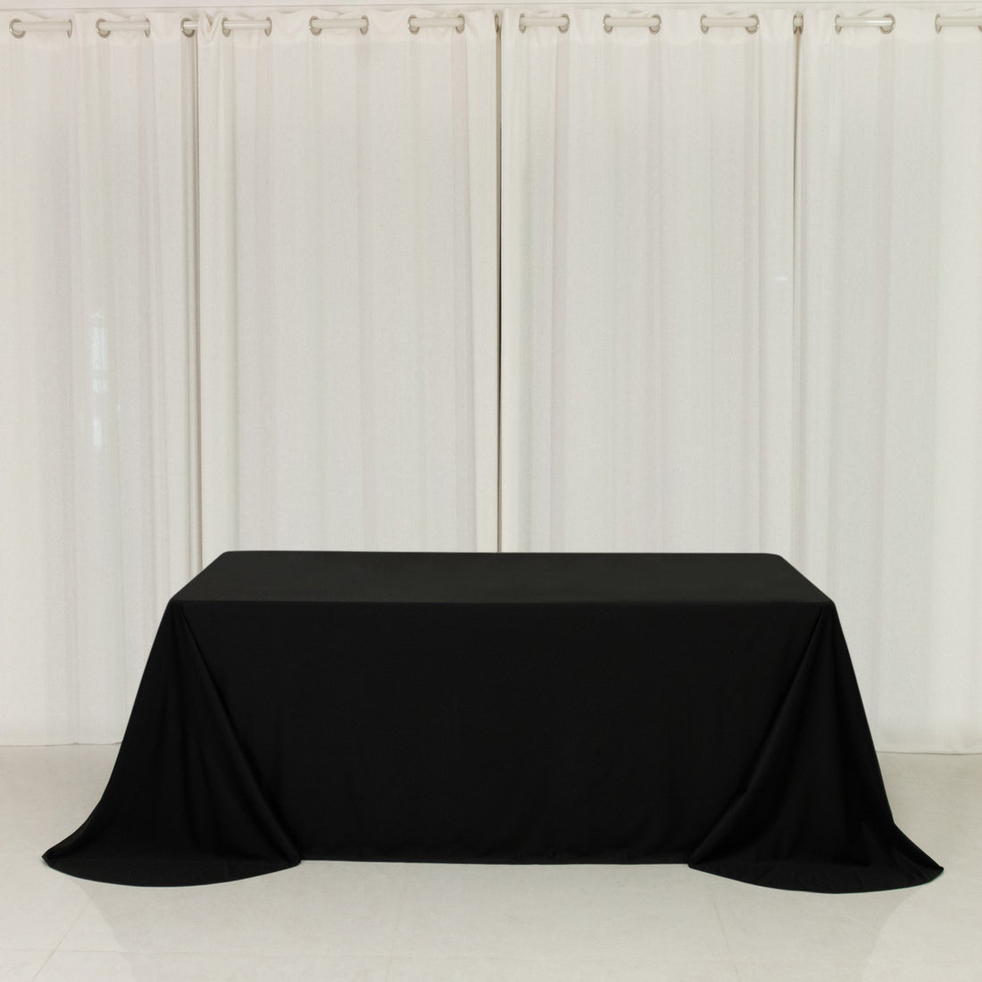 Black tablecloth draped over a table in a minimalistic setting.