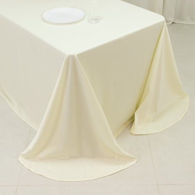 Cream tablecloth draped elegantly over a table with a plate and wine glass.