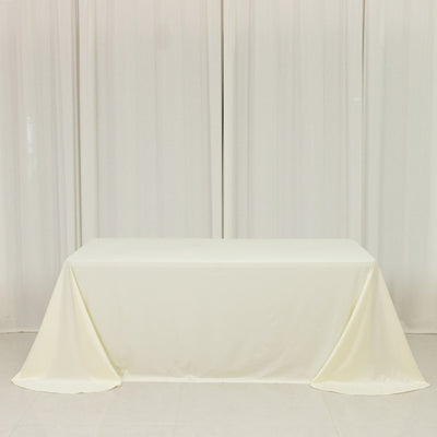 Plain white table with a cream-colored tablecloth draped elegantly.