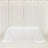 White table covered with a draped cloth in a bright, minimalistic setting.