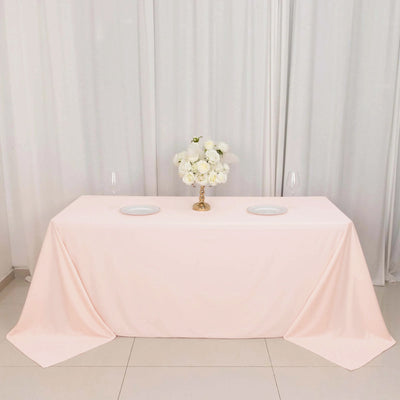 Elegant pink tablecloth with floral centerpiece and dinnerware.