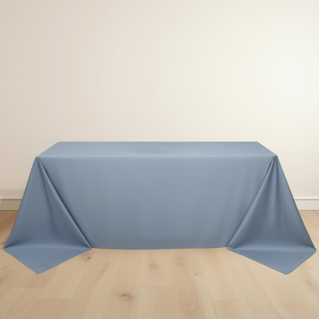 Blue tablecloth draped over a table on a light wooden floor.