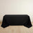 Black tablecloth draped over a rectangular table on a light wooden floor.