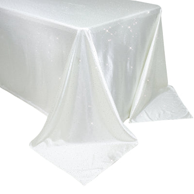 White tablecloth with sparkling details, elegantly draped on a table.