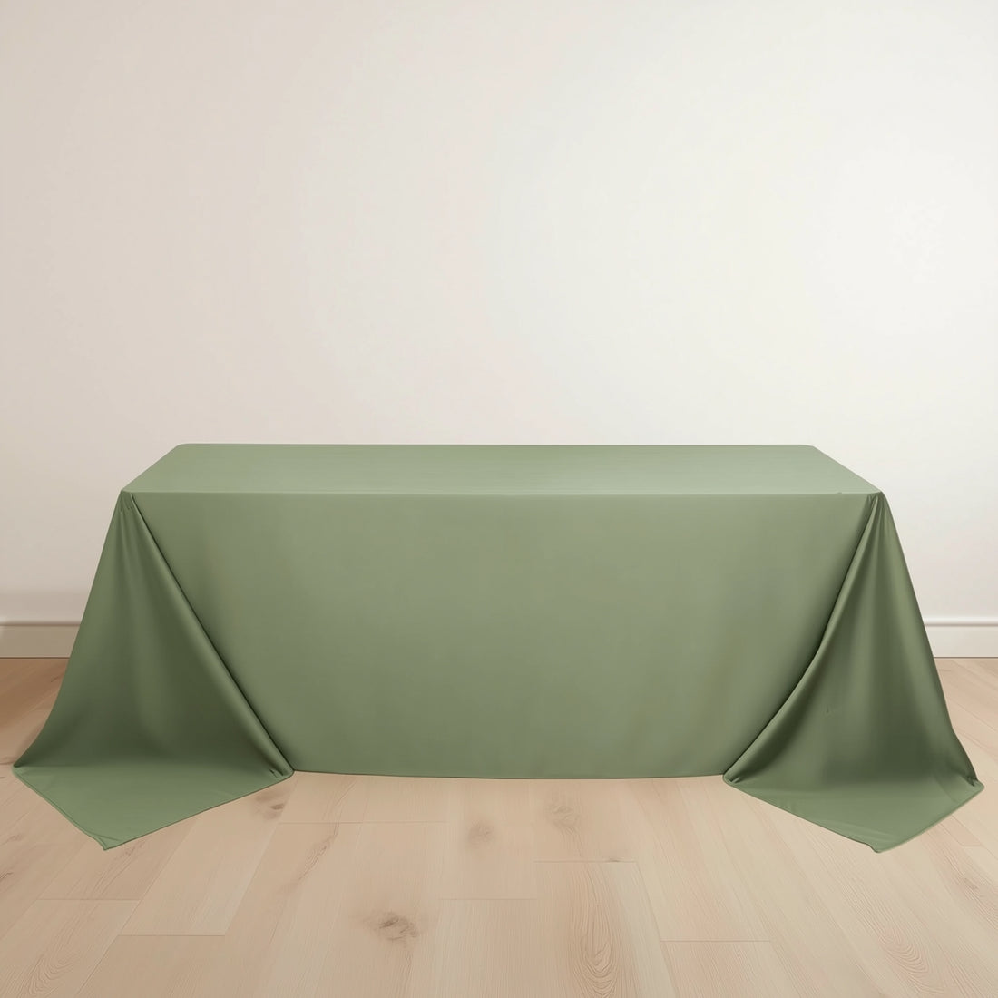 Green tablecloth draped elegantly over a table on a light wooden floor.