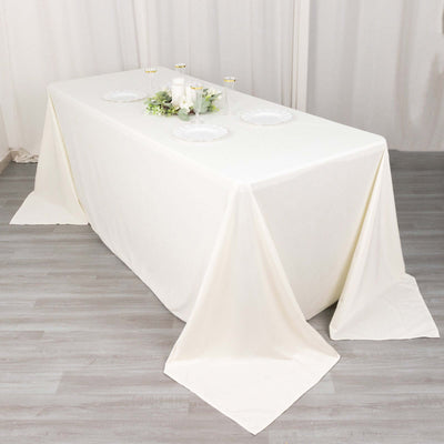 White tablecloth draped over a table set for dining.