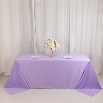 Lavender tablecloth with floral centerpiece on a white backdrop.