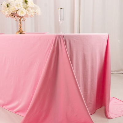 Pink tablecloth elegantly draped on a table with floral centerpiece.