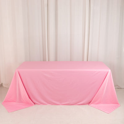 Pink tablecloth draped over a table in a studio setting.