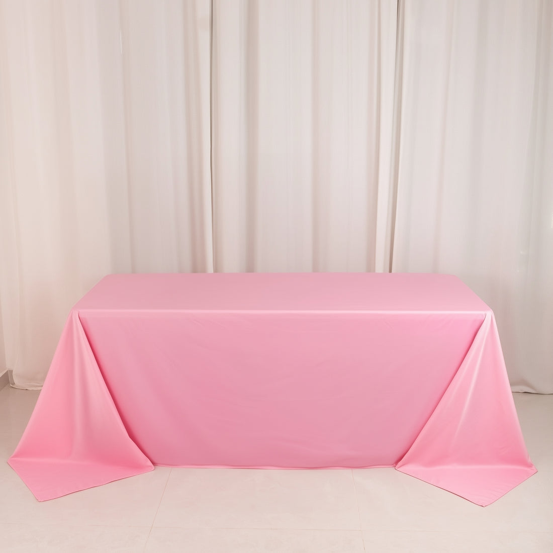 Pink tablecloth draped elegantly over a table in a studio setting