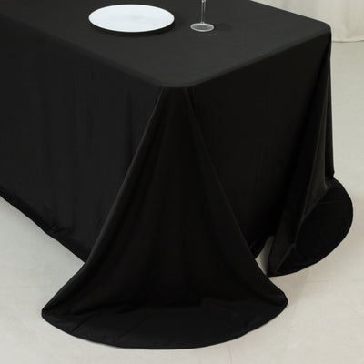 Black tablecloth draped elegantly over a table with a white plate and glass.