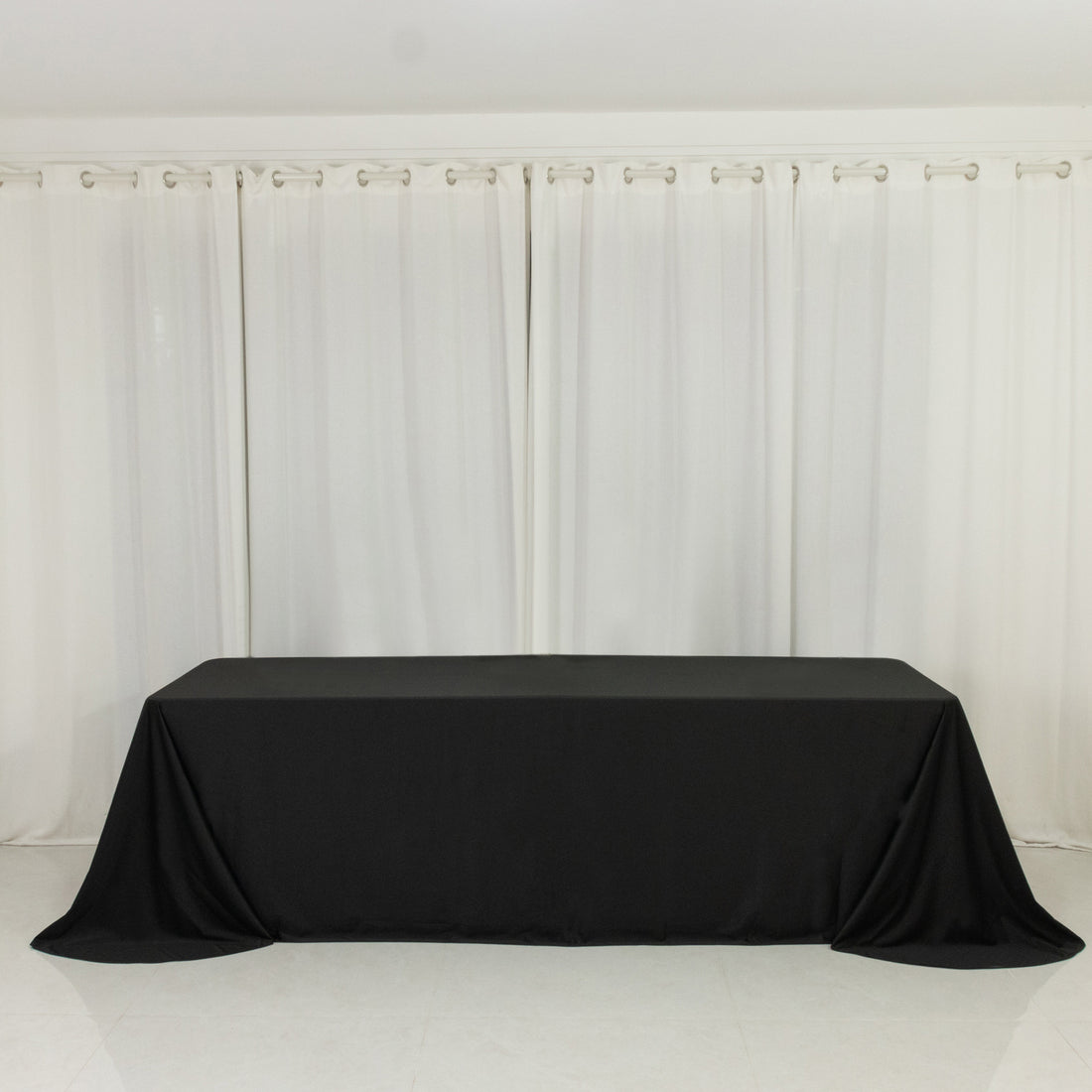 Black tablecloth draped over a table in a minimalist setting.