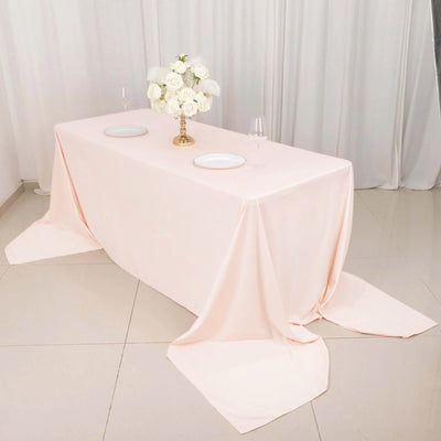 Elegant pink tablecloth draped over a table with floral centerpiece.