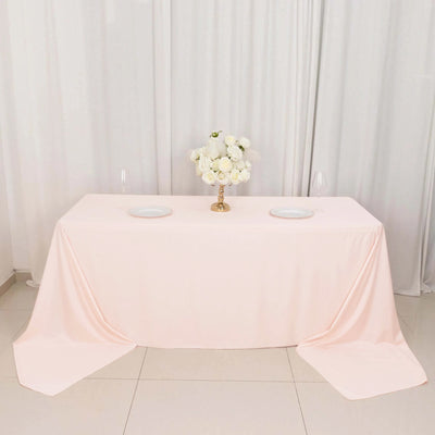 Pink tablecloth draped elegantly over a table with floral centerpiece and plates.