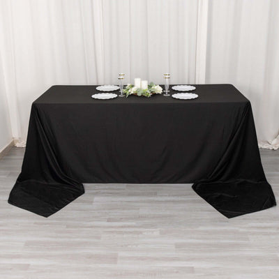 Black tablecloth draped over a table with decorative items on top.