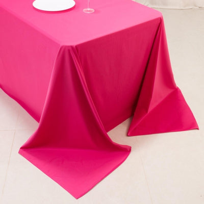 Hot pink tablecloth on event table with plates and glass