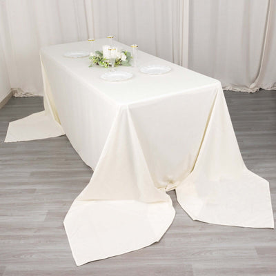 Elegant white tablecloth draped over a table with decorative plates and candles.