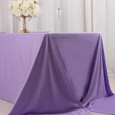 Purple tablecloth draped elegantly on a table with floral centerpiece.