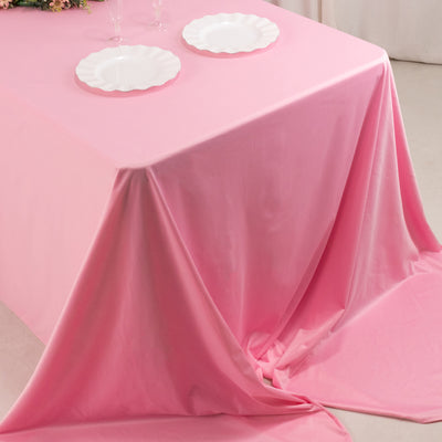 Pink tablecloth draped elegantly over a table with white plates.