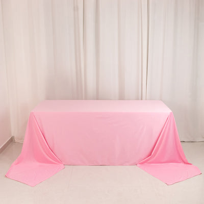Pink tablecloth draped over a table in a studio setting.