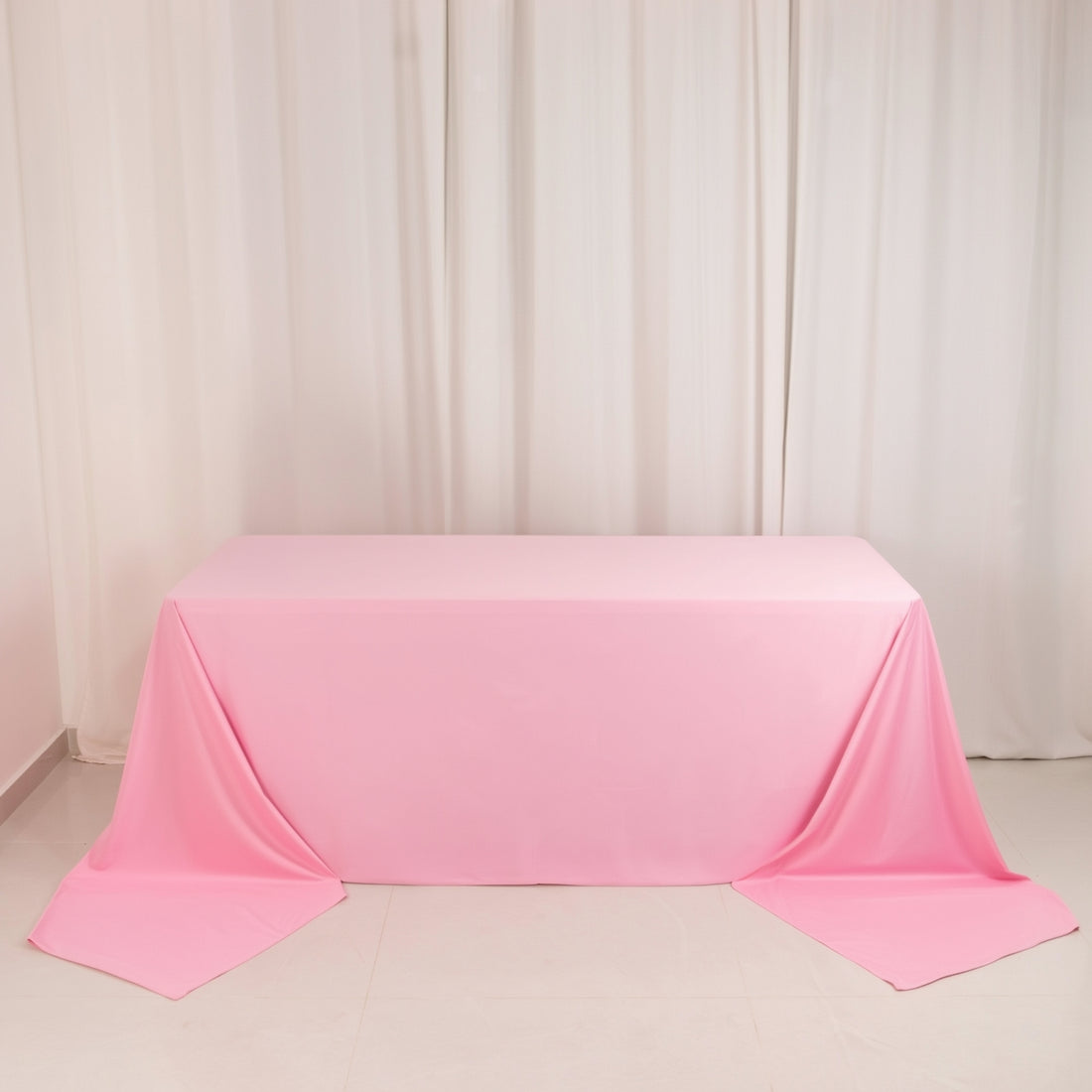 Pink tablecloth draped elegantly over a table in a studio setting.