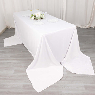 White tablecloth draped elegantly over a dining table with decorative elements.