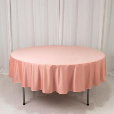 Round pink tablecloth draped over a table in a studio setting.