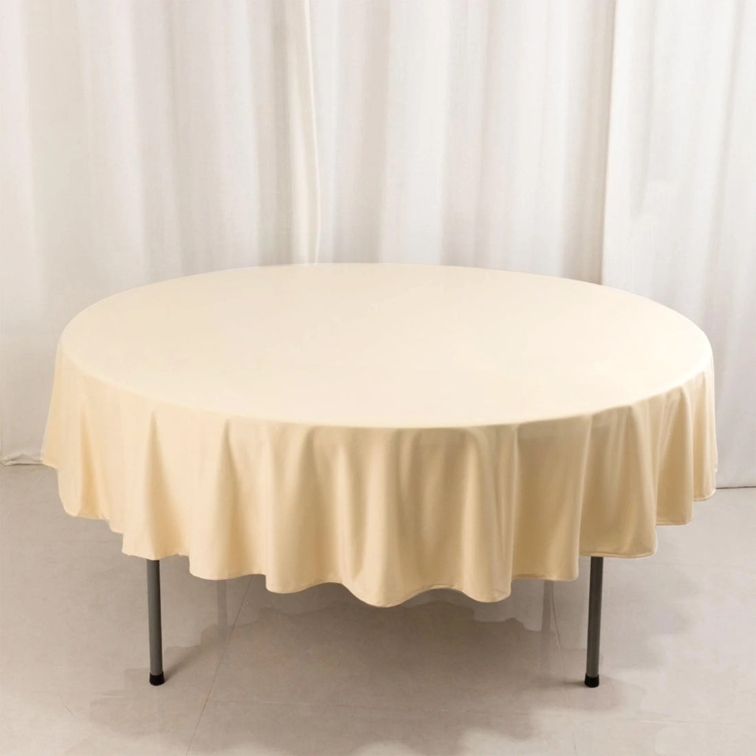 Round beige tablecloth draped over a table