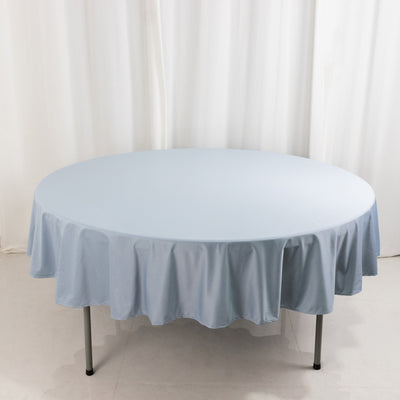 Round blue tablecloth on a table against a plain backdrop