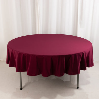 Round burgundy tablecloth draped over a table